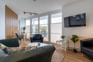 un salon avec un canapé et une télévision dans l'établissement Ferienwohnung Four Twee – Ihr gemütlicher Rückzugsort in SPO, à Sankt Peter-Ording