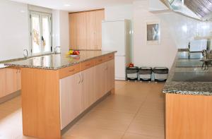 a large kitchen with wooden cabinets and a refrigerator at Albergue Turístico Rio Aragon in Canfranc-Estación