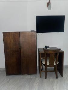 einen Schreibtisch mit einem TV und einem Holzschrank in der Unterkunft Hotel Cartagena Comfort in Cartagena de Indias + 15 Fotos