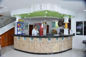 Eine Frau, die auf einem Handy an einer Theke in einem Restaurant spricht. in der Unterkunft Hotel Cartagena Comfort in Cartagena de Indias