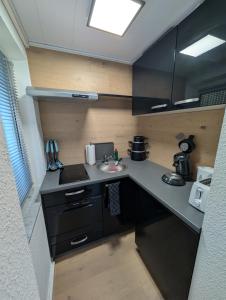 a small kitchen with black cabinets and a sink at Stilvolles Apartment nähe Uni Klinikum in Gießen