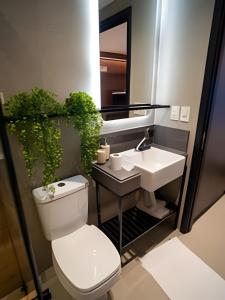 a bathroom with a toilet and a sink at Flat novo, moderno e super bem localizado in Tambaú