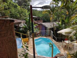 圣路易斯-杜帕赖廷加Pousada e Hostel Cantinho dos Chalés的房屋后院的游泳池