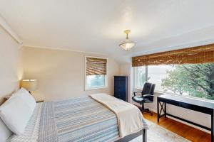 una camera da letto con un letto, una scrivania e una finestra di Whispering Seas with Hot Tub! a Newport