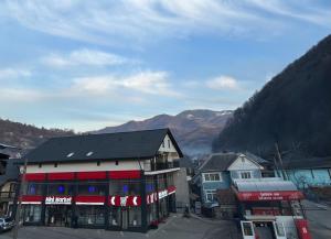 a town with a building and mountains in the background at Roua Ilvei INN in Ilva Mică