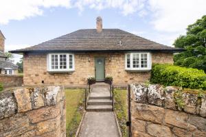 a brick house with a green door and a stone wall at Whatton Cottage in Gullane +7 photos
