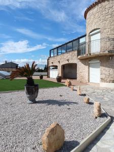 ein großes Steingebäude mit einer Topfpflanze und Felsen in der Unterkunft Villa Les Grenadines RDC in Mèze + 13 Fotos