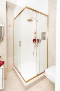 a shower with a glass door in a bathroom at Gold Apartments NMP 35 in Częstochowa