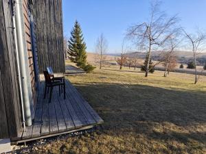 a chair sitting on the porch of a house at Apartmán SOVA - Klínovec in Loučná pod Klínovcem