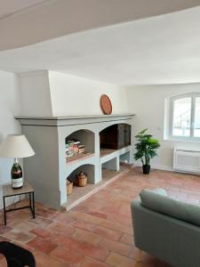 a living room with a fireplace and a couch at Villa Les Grenadines RDC in Mèze