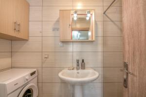 ein Badezimmer mit Waschbecken und Waschmaschine in der Unterkunft Margie's Apartments in Kissamos + 50 Fotos