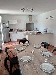 ein Esstisch mit Stühlen und eine Küche in der Unterkunft Villa Les Grenadines RDC in Mèze