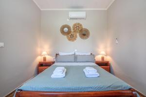 ein Schlafzimmer mit einem Bett mit Handtüchern darauf in der Unterkunft Margie's Apartments in Kissamos