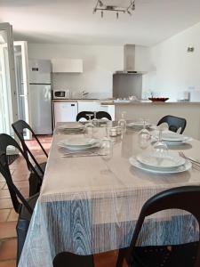 a table with plates and glasses on it in a kitchen at Villa Les Grenadines RDC in Mèze