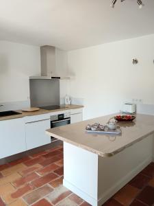 a kitchen with white cabinets and a counter top at Villa Les Grenadines RDC in Mèze