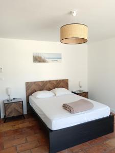 a bedroom with a bed and a light fixture at Villa Les Grenadines RDC in Mèze +13 photos
