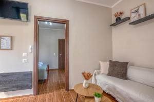 ein Wohnzimmer mit Sofa und Tisch in der Unterkunft Margie's Apartments in Kissamos