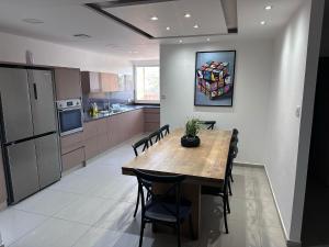 une cuisine avec une table et des chaises dans une pièce dans l'établissement Mila apartment, à Eilat