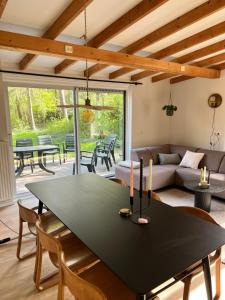 a living room with a table and a couch at Green Escape Hellendoorn rust & natuur in Hellendoorn