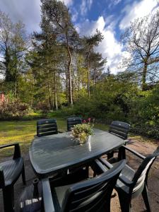 a picnic table with chairs and flowers on it at Green Escape Hellendoorn rust & natuur in Hellendoorn