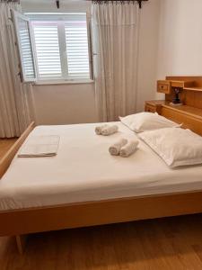 a bedroom with a bed with towels on it at Beachfront Apartment Mery, Kneže in Račišće