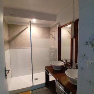 ein Badezimmer mit zwei Waschbecken und einer Dusche in der Unterkunft La longue vue in Les Avirons + 10 Fotos