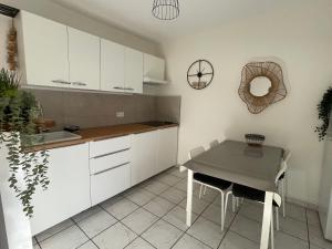 a kitchen with white cabinets and a table at St Martial Sète centre, CLIM in Sète
