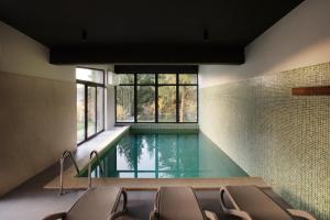 a swimming pool in the middle of a room with chairs at ArkWood Colibita in Colibiţa