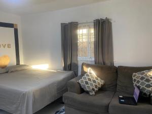 a living room with a couch and a bed at White Room Sparks in Spanish Town