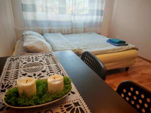 a table with two candles on it with a bed at GUNER Apartament Bełchatów in Bełchatów