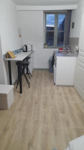 a room with a kitchen with a desk and a table at Chambre indépendante de la Porte du Bois in Joigny +1 photo