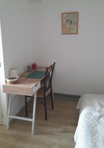 a wooden desk with a chair next to a bed at Chambre indépendante de la Porte du Bois in Joigny