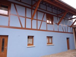 a white building with windows and wooden beams at Maison de vacances centre Alsace in Grussenheim