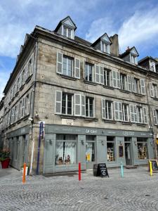 a large brick building on a city street at Le studio louana Appartement neuf et discret tout confort in Aubusson