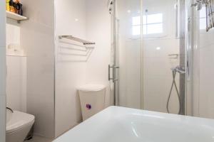 a white bathroom with a shower and a toilet at Calle Goya 108 in Arguineguín