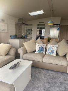 un salon avec un canapé et une table dans l'établissement LODGE SEA VIEW On the beach signature gold Hafan y Mor North Wales LL53 6HX, à Chwilog