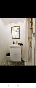 a white bathroom with a sink and a toilet at Studio Cœur de Deauville à 10 minutes à pied de la plage in Deauville