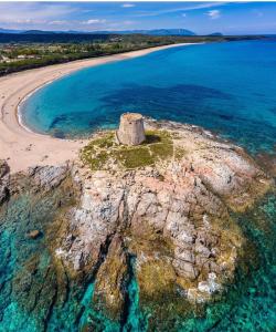 an island in the ocean next to a beach at Le pietre di Mario in Bari Sardo