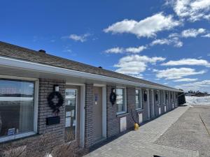 a brick building with a blue sky and clouds at Earlton Motel in Earlton