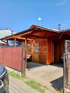 a wooden house with a fence in front of it at Casa Cabaña Oro Rayado Puerto Varas in Puerto Varas