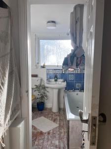a bathroom with a sink and a tub and a toilet at Cornish Cottage in Newquay