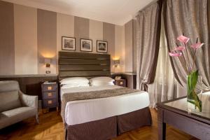 Habitación de hotel con cama y silla en Hotel Royal Court en Roma