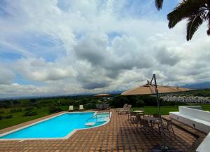 a swimming pool with chairs and an umbrella at Rancho Eden in Armenia