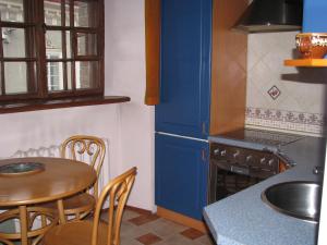 a kitchen with a table and a blue refrigerator at Stasys Apartments Pilies Street in Vilnius