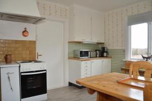 a kitchen with a stove and a wooden table at Pellas Gård in Djura