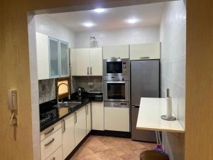 a kitchen with white cabinets and stainless steel appliances at Appartement marina beach f5 n6 in M'diq