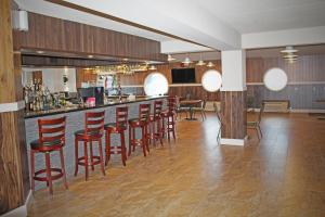 a bar with a row of red stools in a room at Hotel North in North Sydney