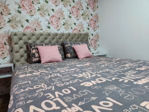 a bedroom with a large bed with pink pillows at Apartman Tara 2 in Sremska Mitrovica