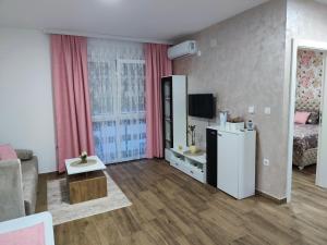 a small living room with a bed and a refrigerator at Apartman Tara 2 in Sremska Mitrovica