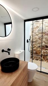 a bathroom with a sink and a toilet and a mirror at La Casita de Aguete in Pontevedra